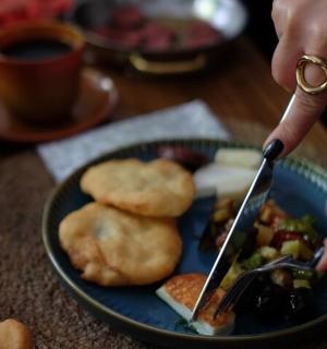 a person with a knife and fork and a plate of food
