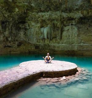 坐在水池中岩石上的人