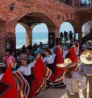 un grup de persones assegudes en cadires prop de l'oceà