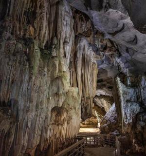 a cave with a rock wall and a staircase in it