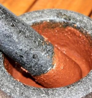 一个研钵和研杵从红色的碗里伸出来。