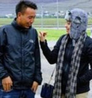 two men standing next to each other in a parking lot