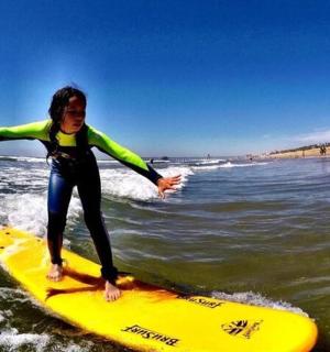 žena jedoucí na vlně na surfovém prkně v oceánu