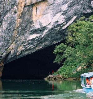 a boat in the water in front of a cave