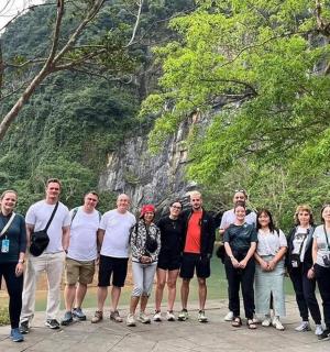 a group of people posing for a picture in front of a mountain