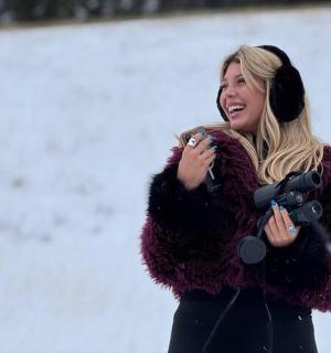 a woman wearing a fur coat talking on a cell phone