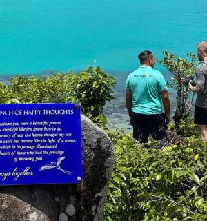 两个男人站在海边,举着一块牌子