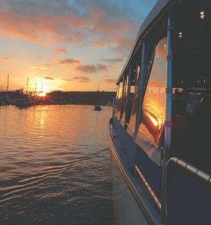 a boat on the water with the sunset in the background