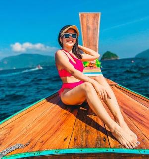 a woman in a bikini sitting on a boat