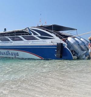a woman standing in the water next to a boat