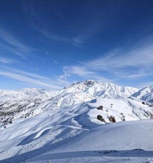 一座白雪皑皑的山峰，背景是群山