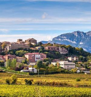 město na kopci s horami v pozadí