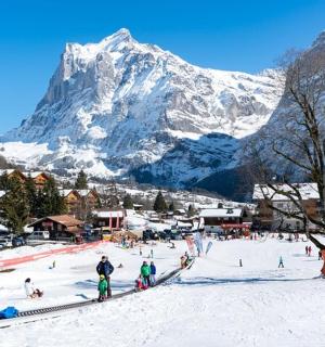 a group of people on a ski slope in front of a mountain