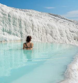 eine Frau, die in einem Pool mit blauem Wasser sitzt
