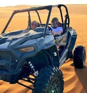 两个人在沙漠中驾驶一辆四轮摩托车