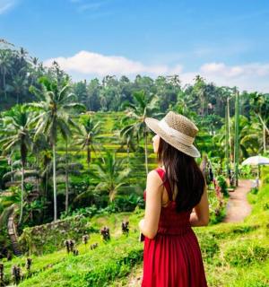 a woman in a hat looking at a rice field