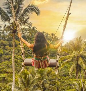 a woman on a rope swing in the jungle
