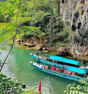 two blue boats on a river near a mountain