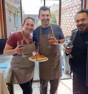 三个人手里拿着酒杯和一盘食物。