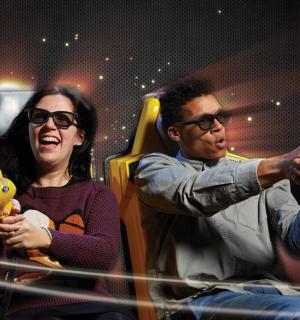 一男一女坐在椅子上,面前放着一台望远镜