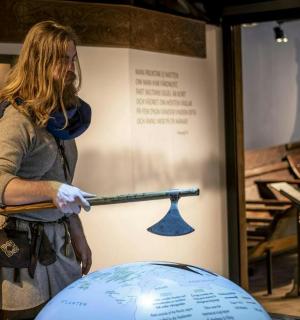 博物馆里，一位女士手持魔杖和地球仪。