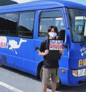 a person holding a sign in front of a bus
