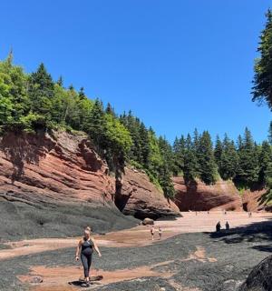 一群人在悬崖附近的海滩上散步