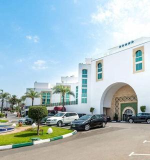 velká bílá budova s auty zaparkovanými na parkovišti