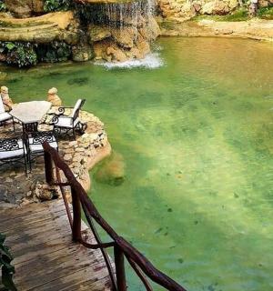 a patio with a table and chairs in a pond