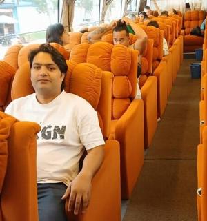 a man sitting in an orange seat on a bus