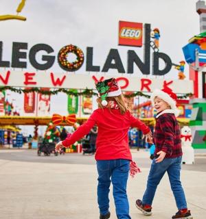 two children are walking in front of a amusement park