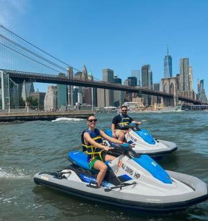 两个人正乘坐水上动力船在河上行驶