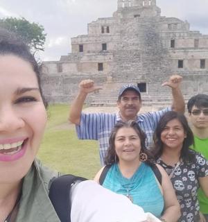 a group of people standing in front of a pyramid