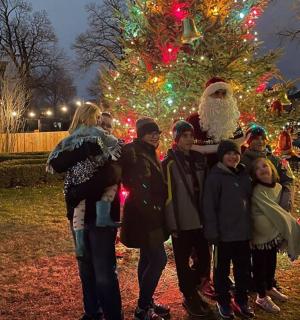 a group of people standing in front of a christmas tree