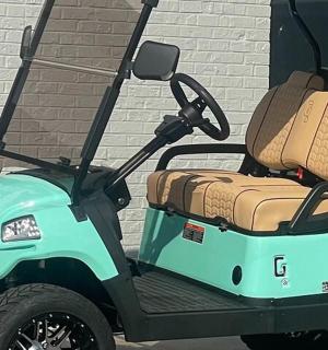 一辆绿色高尔夫球车,后部载着行李。
