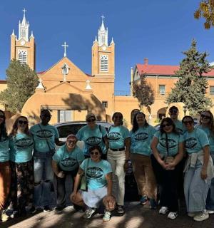 skupina lidí pózujících pro fotografii na parkovišti