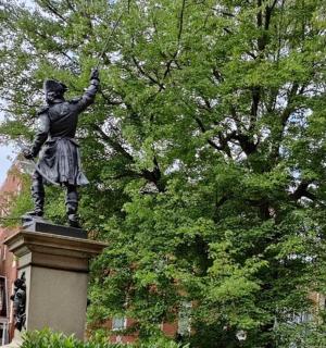 站在树顶的男人雕像