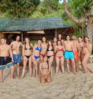 a group of people posing for a picture on the beach