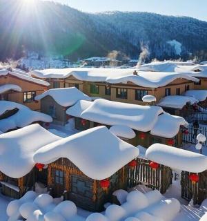 město pokryté sněhem se sluncem v pozadí