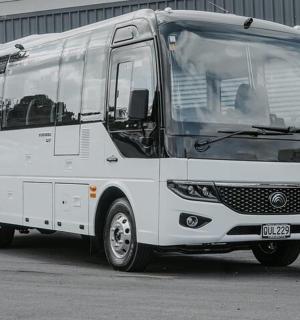 bílý autobus zaparkovaný na parkovišti