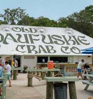 一群人坐在餐厅前的桌子旁