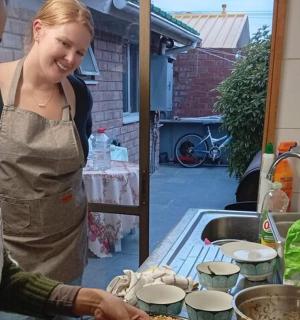 一位女士站在厨房准备食物