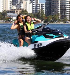 two women riding on a jet ski in the water
