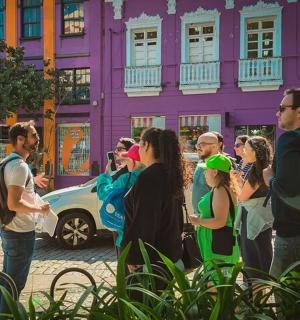 a group of people standing in front of a colorful building