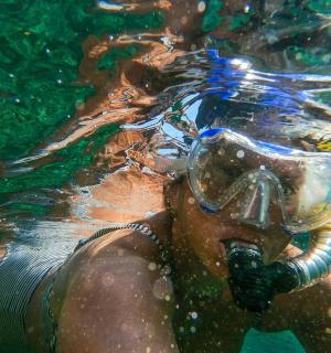 戴着潜水面罩在水中游泳的人