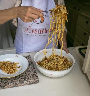 a person is holding a bowl of noodles