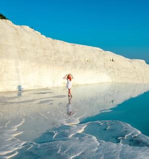 a woman standing on a beach near the water