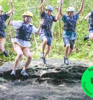 a group of people jumping off a rock on a trail