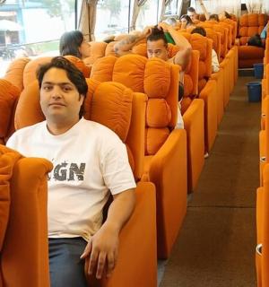 a man sitting in an orange seat on a bus