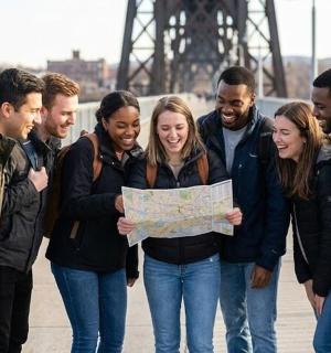 a group of people standing together holding a map